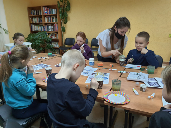Педагог Дарья Окуневич показывает детям, как рисовать акрилом на шарике